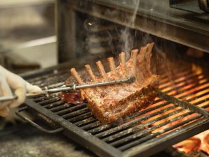 Grilled lamb chops prepared over an open flame at Royal Crown Grill House